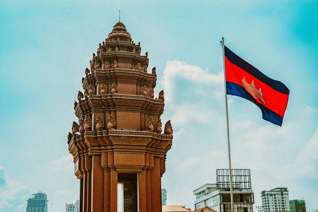 The Cambodian flag flies next to an ornate templae pagoda.